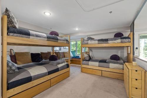 a room with three bunk beds in a house at New host! Exceptional Sunday River Ski In Ski Out Condo in Newry