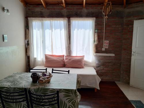 a bedroom with a bed with a table and a window at Departamento Puerto Madryn! Patagonia Beach in Puerto Madryn