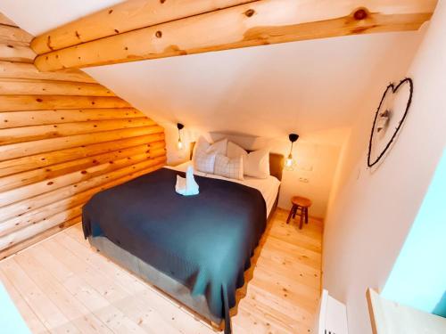 a bedroom in a log cabin with a bed at Pur Natur! Wandern und Skifahren - Trahütti Premium Lodges in Trahütten
