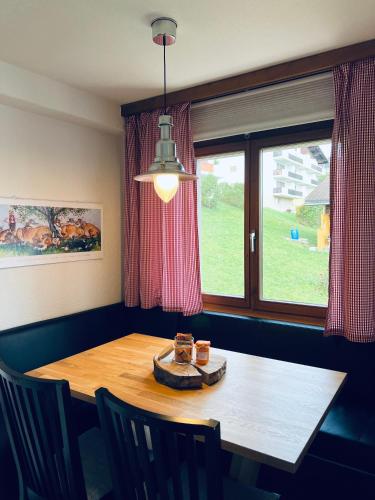 a dining room table with chairs and a window at Steinbock - CharmingStay in Flumserberg