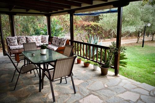 een patio met een tafel en stoelen op een veranda bij Endless View in Mesimvría