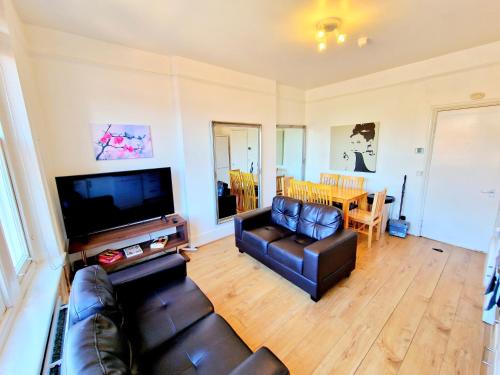a living room with a couch and a flat screen tv at King's Cross 4 Bedrooms Home with Private Rooftop in London