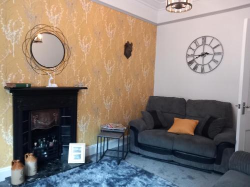 a living room with a couch and a mirror at The Nifty Nook in Campbeltown