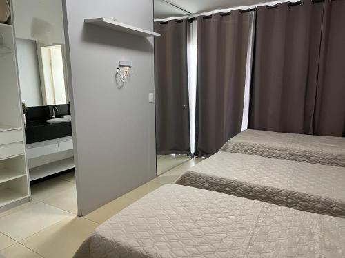 1 dormitorio con 2 camas individuales y espejo en Mirante de Escarpas 1402, en Capitólio