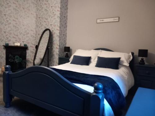 a bedroom with a blue and white bed and a mirror at The Nifty Nook in Campbeltown