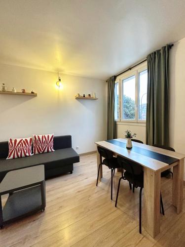 un salon avec une table et un canapé dans l'établissement ULTimade Apartment T3 proche Paris/Tramway & Métro, à Ivry-sur-Seine