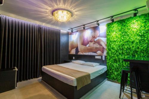 a bedroom with a bed with a green wall at Motel Paradiso Carazinho (Adults Only) in Caràzinho