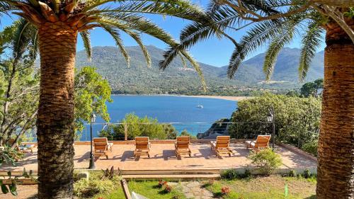 een patio met stoelen en uitzicht op een meer bij A'mare Corsica I Seaside Small Resort in Propriano