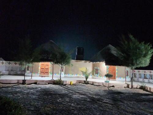 a house at night with palm trees in front of it at Rann Kandhi in Dhordo