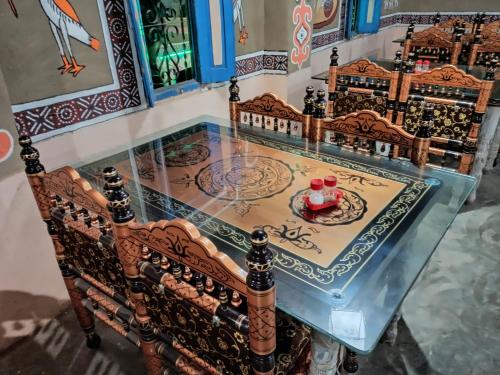 a glass counter with a table with two cups on it at Rann Kandhi in Dhordo