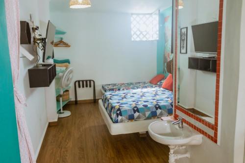 a small bedroom with a bed and a sink at Francechy's Apartamentos 201 in Cartagena de Indias