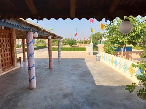 a covered walkway with flags in the background at Rann Kandhi in Dhordo