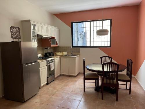 a kitchen with a table and a refrigerator at Apartahotel Alvear in Santo Domingo