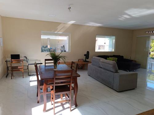 uma sala de estar com uma mesa e um sofá em casa ampla com PISCINA e área verde em São José ao lado de Maragogi em São José da Coroa Grande