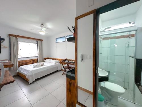 um quarto com uma cama e uma casa de banho com um chuveiro em Suíte confortável no Centro de Caratinga em Caratinga