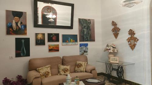 a living room with a couch and pictures on the wall at Una casa azul en el sur in Manzanilla
