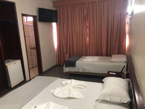 a hotel room with two beds and a window at Avalon Executive in Goiânia