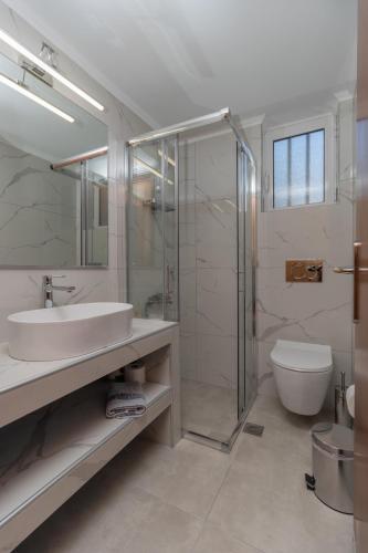 a bathroom with a sink and a shower and a toilet at Lagouvardos Beach Apartments in Marathopoli