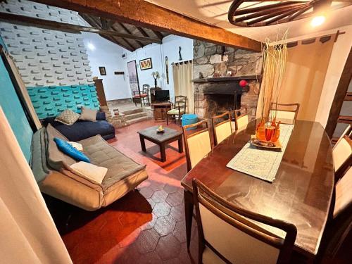 a living room with a table and a fireplace at El rancho - Espaciosa Casa para 7 en un Oasis de Tranquilidad in Villa Serrana
