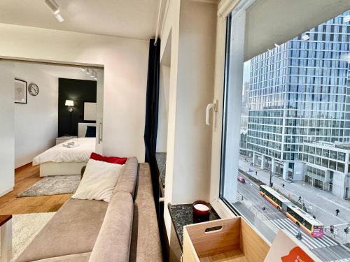 uma sala de estar com um sofá e uma grande janela em FORUM 3 metro fast WiFi 400 Mbs TV HBO Disney+ em Varsóvia