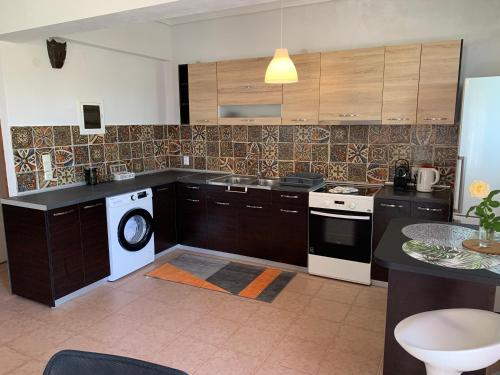 a kitchen with a stove and a dishwasher at La Bandolaise à Perdika in Perdika
