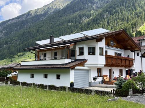 a house with solar panels on top of it at Apartment Familie Thomas und Angelika Melmer in Sankt Leonhard im Pitztal