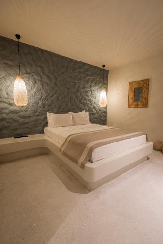 a bedroom with a large bed with two lights on it at Bitez Corner Boutique Hotel in Bitez