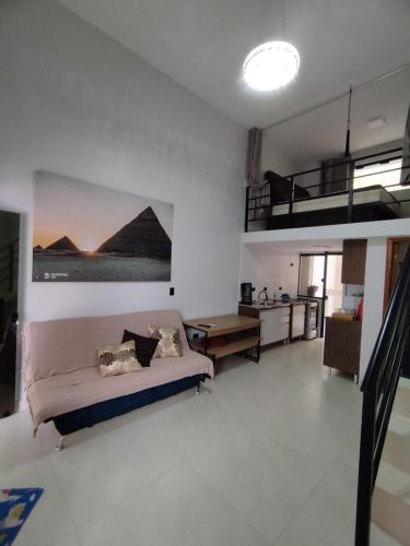 a living room with a bed and a loft at GUARATUBA LOFTS in Guaratuba