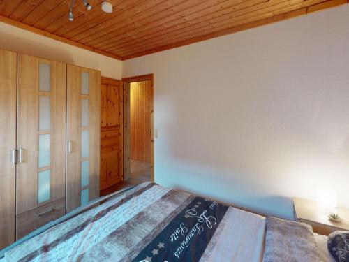 a bedroom with a bed and a wooden ceiling at Ferienhaus Reet am Useriner See in Userin