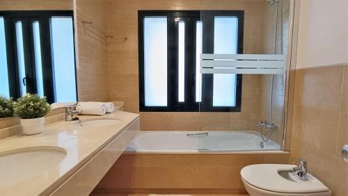 een badkamer met een bad, een toilet en een wastafel bij Casa Rust en Ruimte in Murcia