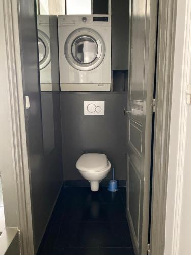 ein kleines Bad mit einem WC und einer Waschmaschine in der Unterkunft Appartement à 50m de Paris in Clichy
