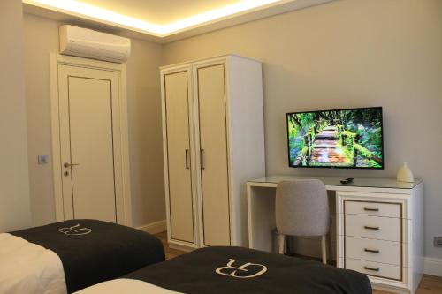 a bedroom with two beds and a desk and a tv at Garlon Residence in Istanbul
