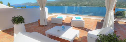 a patio with white furniture and a swimming pool at A'mare Corsica I Seaside Small Resort in Propriano