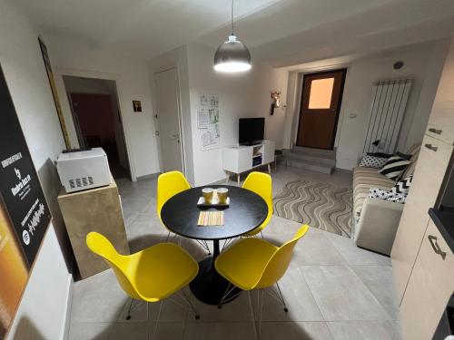 ein Wohnzimmer mit einem Tisch und gelben Stühlen in der Unterkunft JAZZ Apartment Centro storico in Perugia