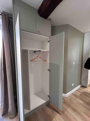 un placard blanc dans une pièce avec du parquet dans l'établissement La Vie est Belle à Montreuil Wi-Fi & Métro 9 Parking gratuit, à Montreuil