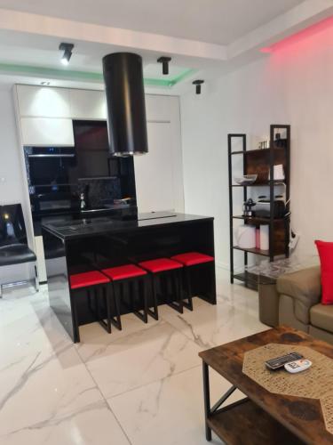 a living room with a black counter and red chairs at Apartament Przy Starym Mieście in Szczecin