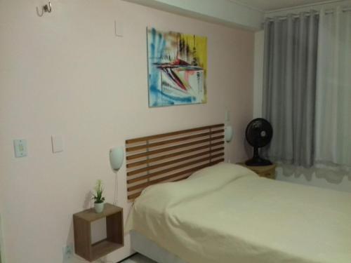um quarto com uma cama e um quadro na parede em Apartamento Praia de Iracema em Fortaleza