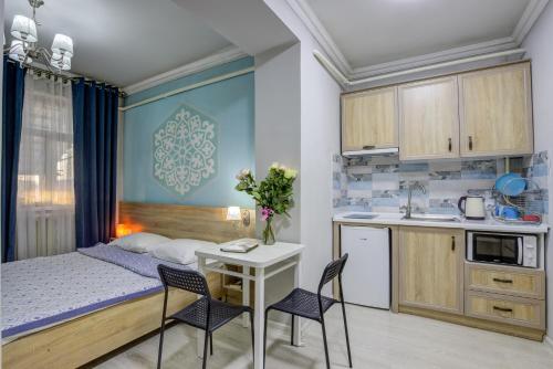 Apartamento pequeño con cama, mesa y sillas en Viva Hotel, en Bishkek
