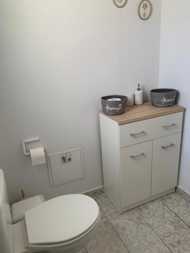 a bathroom with a toilet and two baskets on a counter at La Bandolaise à Perdika in Perdika