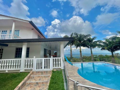 una casa con piscina y palmeras en El paraiso glamping, en Villavicencio