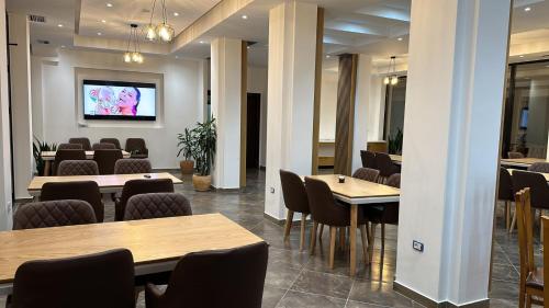 a meeting room with tables and chairs and a tv at Hotel Verzaci in Rinas