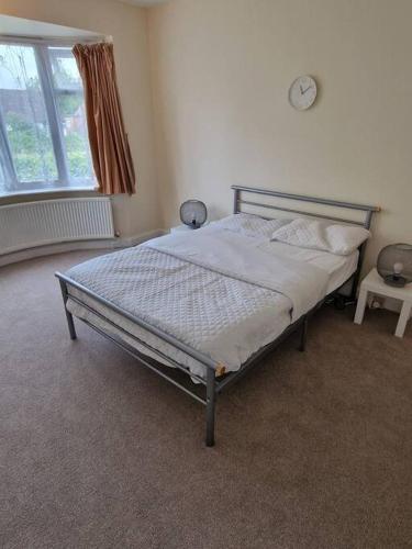 a bedroom with a bed in a room with a window at Lovely 2 bedroom bungalow ! in Saint Albans