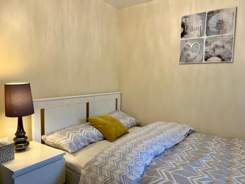 a bedroom with a bed and a lamp on a night stand at Comfort Home in Gillingham