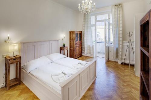 プラハにあるV Kolkovně 5 - Old Town Residenceのベッドルーム(大きな白いベッド1台、シャンデリア付)