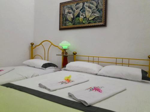 2 Betten in einem Zimmer mit Handtüchern darauf in der Unterkunft Casa de huéspedes la Casona. in Medellín