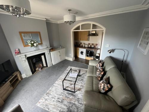 a living room with a couch and a fireplace at The Ingleside Apartment in Basingstoke