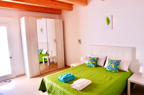 ein Schlafzimmer mit einem grünen Bett mit zwei Handtüchern darauf in der Unterkunft Una Vita In Vacanza in Comiso