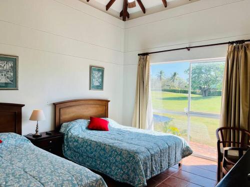 1 dormitorio con 2 camas y ventana grande en 3BR/3.5BA Golf & Beach Villa, en Río Hato