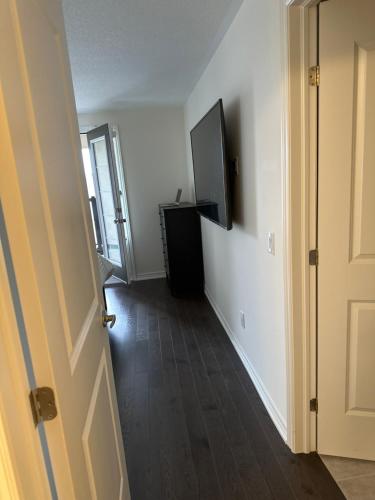 an empty hallway with a television and a door at ON Residence in Hamilton