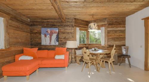a living room with an orange couch and a table at Apartment Stockerdörfl Natur & Ruhe in Kitzbühel in Kitzbühel
